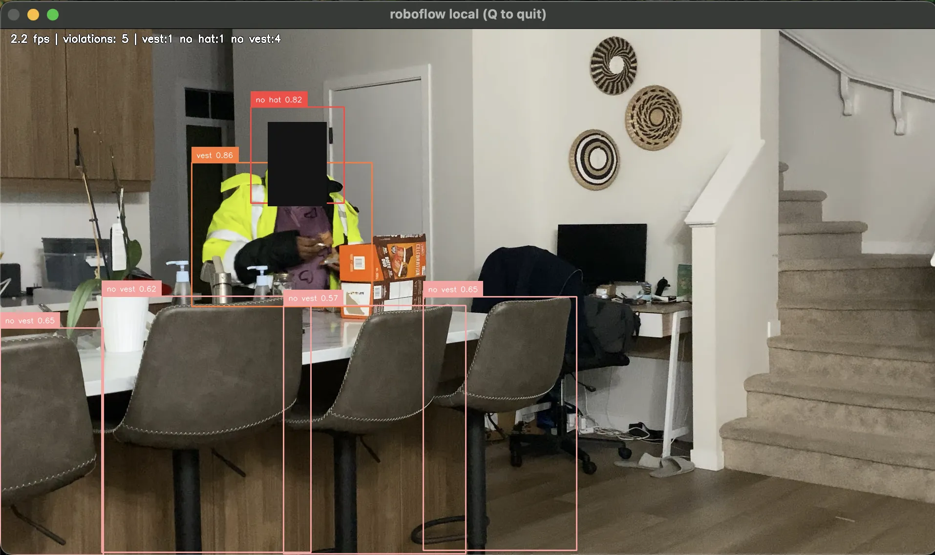 A live frame from the detector. The person in the hi-vis jacket is correctly tagged vest at 0.86, and four bar stools behind them are tagged no vest at 0.57 to 0.65.